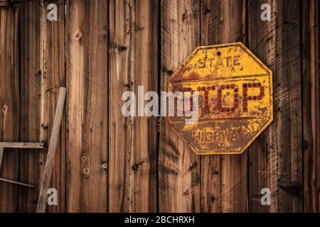 Rostende Stoppschild am Klappbrett Gebäude. Nelson, Nevada, Usa Stockfoto