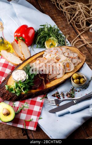 Aufschnitt - verschiedene Fleischsorten, auf dem Hintergrund eines Holztisches Stockfoto