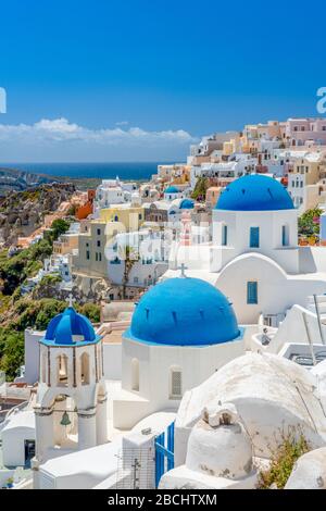 Santorini Griechenland, blaue Kuppelkirchen in Oia mit weißen Wänden gegen einen blauen Himmel. Oia berühmte drei blaue Kuppeln Stockfoto