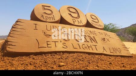 Eine Sandskulptur des Sandkünstlers Ajay Rawat auf der Botschaft von PM Modi an Lampen, die einen unberührten Geist zum Kampf gegen Coronavirus in Pushkar zeigen sollen. Stockfoto