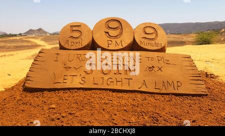 Eine Sandskulptur des Sandkünstlers Ajay Rawat auf der Botschaft von PM Modi an Lampen, die einen unberührten Geist zum Kampf gegen Coronavirus in Pushkar zeigen sollen. Stockfoto