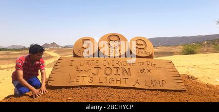 Ein Sandkünstler Ajay Rawat gibt seiner Sandskulptur eine letzte Note auf PM Modis Botschaft an die Lampen, um einen dämmungslosen Geist zum Kampf gegen Coronavirus zu zeigen. Stockfoto