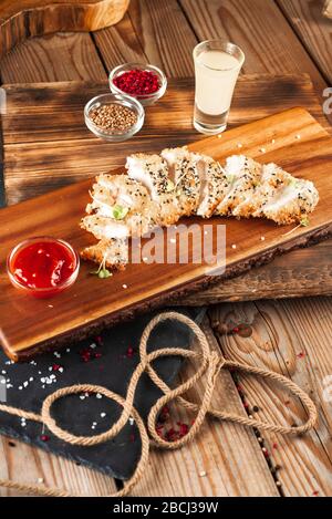 Gebackene Fische in Brotkrümeln mit Sauce. Nahaufnahme, Draufsicht Stockfoto