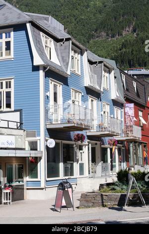 ODDA, NORWAY-CIRCA JUL, 2018: Kleine blaue und rote Häuser befinden sich in der Stadt Odda. Es ist eine Gemeinde im Hordaland-Kreis und Hauptwirtschaftsland Stockfoto