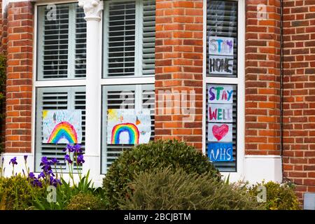 Rainbow und NHS, bleiben Sie gut und bleiben Sie auf dem Heimweg von Bildern, die von Kindern in Anerkennung der Schulschließung durch die Covid-19-Epidemie, London, produziert wurden Stockfoto