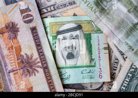 Saudia Arabia Riyal platzierte sich neben US Dollar und chinesischem Yuan Closeup. Selektiver Fokus Stockfoto