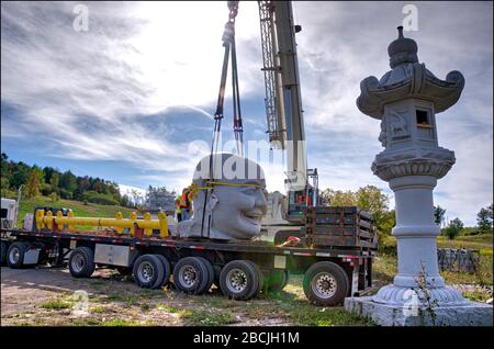 Die Verladung der Steinstatue per Kranwagen im Gebäude des Buddha Maitreya. Stockfoto