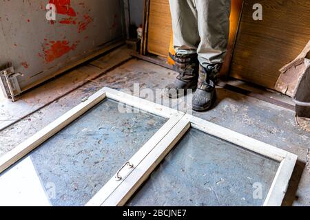 Person Mann in der Garage Werkstatt Lagerraum mit alten Glas Kaltfenster Rahmen für Garten in der Ukraine dacha Stockfoto