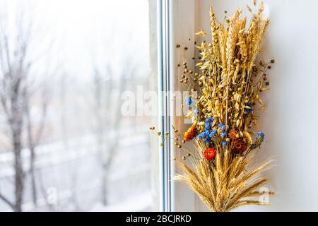 Blumentrocknung in traditioneller ukrainischer Tradition zu Weihnachten Didukh auf Fensterbank mit getrocknetem Blumenstrauß im Winter Stockfoto