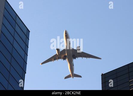 Tokio, Japan. April 2020. Ein Jetliner fliegt am Samstag, 4. April 2020, in Shingawa in Tokio über Gebäude. Neue Flugroute, die sich dem Flughafen Tokios Haneda näherte, wurde diese Woche in Betrieb genommen und flog über Wolkenkratzer in den Geschäftsvierteln Shinjuku, Shibuya und Shinagawa. Credit: Yoshio Tsunoda/AFLO/Alamy Live News Stockfoto