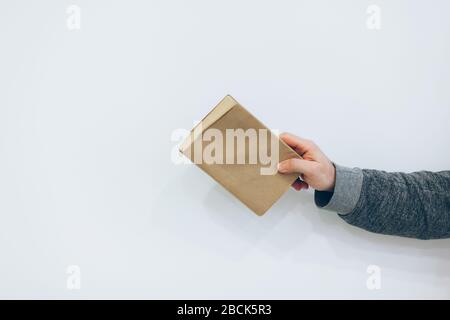 Junger Mann hält nahes altes Papierbuch auf weißem Hintergrund Stockfoto