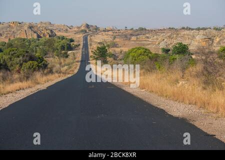 Afrika, Madagaskar, Region Ilhorombe, Ilakaka. Gepflasterte Straße zur Stadt. Eines der weltweit größten bekannten alluvialen Saphirlagerstätten, die 1998 entdeckt wurden. Stockfoto