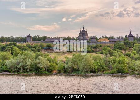 Die mittelalterlichen Zaporozhian-Gebäude auf der Insel Khortytsia in der Ukraine. Dnieper Fluss bei Sonnenuntergang. Stockfoto