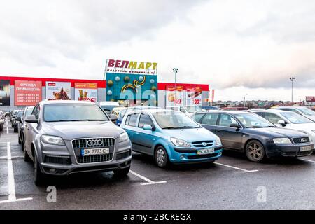 Rivne, Ukraine - 4. Januar 2020: Westukrainische Stadt Rovno mit Parkplatz und Schild für Velmart oder Welmart Lebensmittelgeschäft im berühmten Ekvator Shoppi Stockfoto