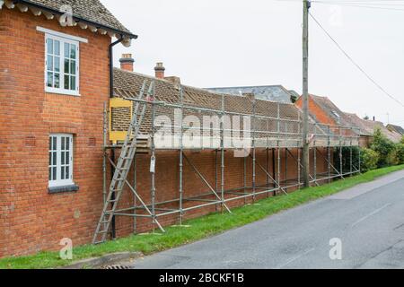 Gerüste und Dachreparaturen, die Dachziegel auf einem ländlichen Haus in Buckinghamshire, Großbritannien, ersetzen Stockfoto