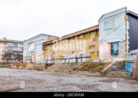 Rivne, Ukraine - 12. Januar 2020: Altes heruntergefallenes verlassenes Industriegebäude in der westukrainischen Stadt mit zerbrochenem äußeren und Schild Stockfoto