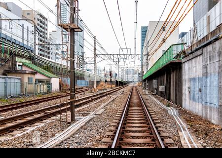 Tokio, Japan - 28. März 2019: Städtische Straße und Gebäude in Shinjuku am Morgen mit Bahnübergängen mit vielen Industriedrähten Stockfoto