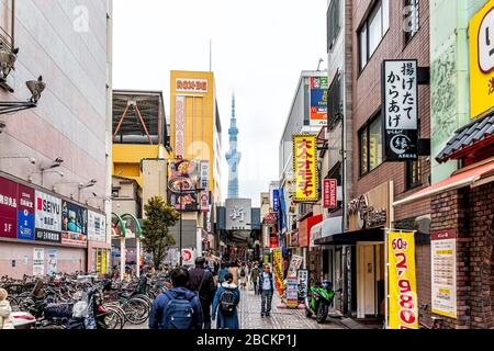 Tokio, Japan - 30. März 2019: Asakusa-Bezirk mit blick auf den skytree Tower in der Innenstadt am bewölkten Tag und Touristen, die durch Geschäfte laufen Stockfoto