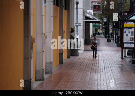 Portland, USA. April 2020. Eine Frau läuft am 3. April 2020 an einem Laden in Louis Vuitton im Einkaufszentrum Pioneer Place in Portland, Ore. vorbei, während die Menschen weiterhin soziale Distanzierungsmaßnahmen in Verbindung mit einem landesweiten Aufenthalt zu Hause praktizieren, um die Verbreitung des neuartigen Coronavirus zu verlangsamen. (Foto von Alex Milan Tracy/Sipa USA) Credit: SIPA USA/Alamy Live News Stockfoto