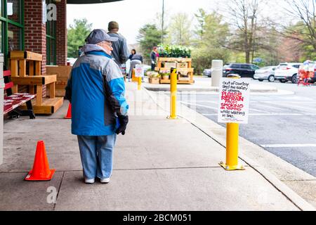 Reston, USA - 1. April 2020: Händler Joes Lebensmittelladen unterzeichnen für Kunden, auf das Rauchen mit Menschen zu verzichten, Klein-Person-Zwerg mit Standin Stockfoto