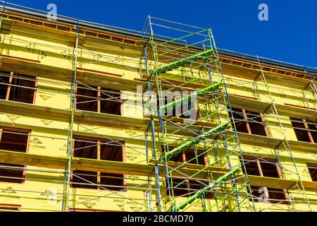 Gerüstzugang Treppen an der neuen Mehrfamilien-Wohnhausfassade, die während des Bauens durch GFK-Mattengipsummantelung geschützt ist - Santa Jose Stockfoto