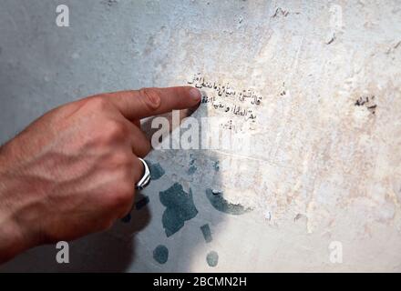 ISTANBUL, TÜRKEI - 23. JULI: Prayer Leader (Imam) zeigt alte arabische Graffiti in der Arap Moschee am 23. Juli 2013 in Istanbul, Türkei. Die Moschee war ursprünglich eine im Jahre 1325 errichtete Römisch-Katholische Kirche. Stockfoto