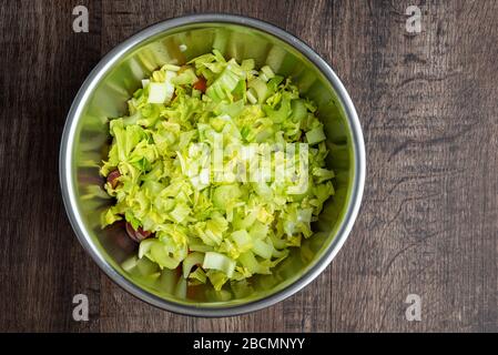 Gehackte Sellerie in einer Edelstahlschale auf einem Holztisch Stockfoto