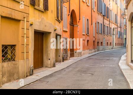 MODENA (MO), ITALIEN - 15. FEBRUAR 2019: Sonnenlicht ist ein erhelltes Haus in der Straße des historischen Zentrums von Modena Stockfoto