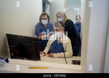 Berlin, Deutschland. April 2020. Vier Schwestern sehen sich einen Computerbildschirm im Untersuchungsraum Corona der Virchow-Klinik an. In Berlin wurden bisher mindestens 48.771 Laborversuche für das neue Corona-Virus durchgeführt. (Zu 'mindestens 48.771 in Berlin durchgeführte Corona-Tests') Credit: Jörg Carstensen / dpa / Alamy Live News Stockfoto