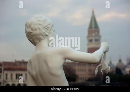 Statue des Jungen mit Frosch von Charles Ray, Punta della Dogana mit Markusplatz im Hintergrund, Venedig, Italien Stockfoto