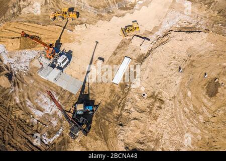 Schwere Baumaschinen, die auf der Baustelle arbeiten, Luftbild von fliegender Drohne Stockfoto