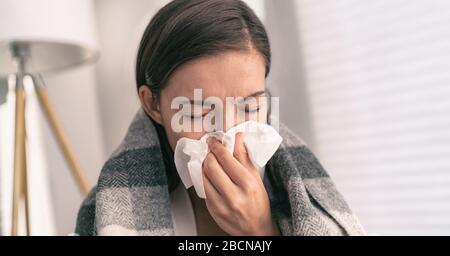 Husten Sie im Gewebe, das Nase und Mund bedeckt, wenn Sie gemäß den COVID-19-Hygienerichtlinien für die Vorbeugung von Coronavirus-Ausbreitung husten. Asian Woman krank mit Grippe zu Hause. Stockfoto