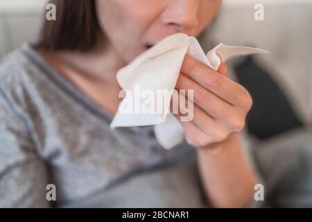 Husten Sie im Gewebe, das Nase und Mund bedeckt, wenn Sie gemäß den COVID-19-Hygienerichtlinien für die Vorbeugung von Coronavirus-Ausbreitung husten. Stockfoto