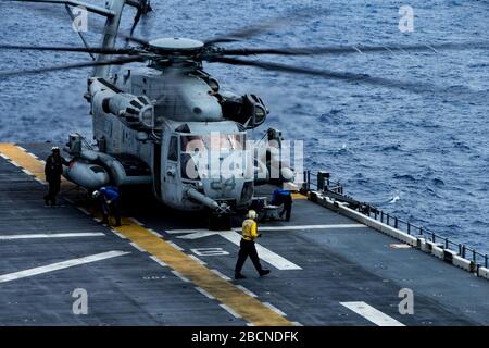 PHILIPPINISCHE SEE (30. März 2020) EIN Super Stallion Hubschrauber CH-53E mit Marine Medium Tiltrotor Squadron (VMM) 265 (verstärkt) 31. Marine Expeditionary Unit (MEU) bereitet sich auf den Start vom Flugdeck des amphibischen Angriffsschiffs USS America (LHA 6) während des Flugbetriebs vor. Der Flugbetrieb soll sicherstellen, dass alle Geräte ordnungsgemäß funktionieren und den Piloten die Möglichkeit geben, ihre Flugstunden zu ergänzen. Amerika, Flaggschiff der America Expeditionary Strike Group, 31. MEU-Team, ist im 7. US-Flottengebiet tätig, um die Interoperabilität mit Verbündeten und Par zu verbessern Stockfoto