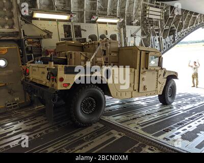 A Soldier from A Company, 63rd Expeditionary Signal Battalion, 35th Signal Brigade Assigned to Fort Stewart, GA. Move their High Mobility Multipurpose Wheeled Vehicle (HMMWV) beladen with Communication Equipment on a Plane at Hunter Army Airfield, 4. April 2020. Der 63. ESB verschiebt Personal und Ausrüstung zur Unterstützung des US-Nordkommandos und des Antrags der US-Armee Nord auf Verteidigungsunterstützung durch zivile Behörden als Reaktion auf die COVID-19-Pandemie, indem er Kommunikationshilfen für von COVID-19 betroffene Gebiete bereitstellt. (USA Armeefoto des Personals Sgt. Joseph Truckley) Stockfoto