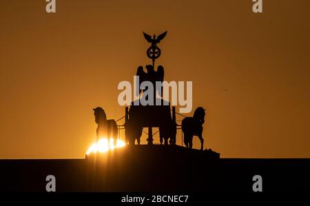 Berlin, Deutschland. April 2020. Hinter dem Brandenburger Tor erhebt sich die Sonne. Kredit: Paul Zinken / dpa-zb-Zentralbild / dpa / Alamy Live News Stockfoto