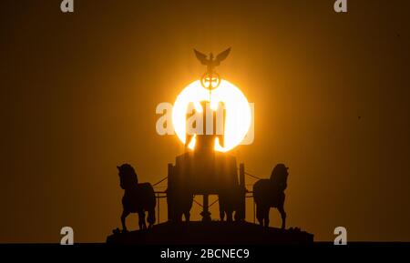 Berlin, Deutschland. April 2020. Hinter der Quadriga am Brandenburger Tor steigt die Sonne auf. Kredit: Paul Zinken / dpa-zb-Zentralbild / dpa / Alamy Live News Stockfoto