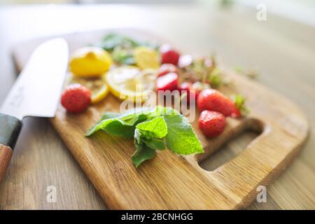 Trinken, Nahaufnahme auf dem Schneidebrett Erdbeeren Minze Zitrone, Messer Stockfoto