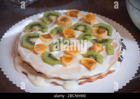 Hausgemachter Kuchen mit Honig, verzieren mit exotischem Obst: kiwi und Banane. Hausgemachter Kuchen mit Obst Stockfoto