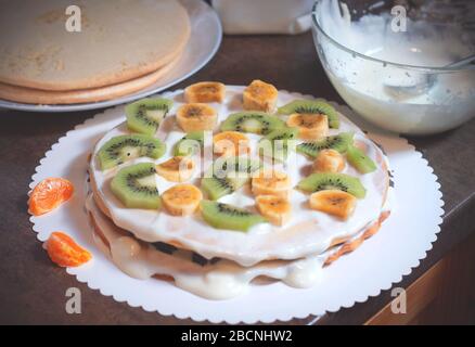 Hausgemachter Kuchen mit Honig, verzieren mit exotischem Obst: kiwi und Banane. Hausgemachter Kuchen mit Obst Stockfoto