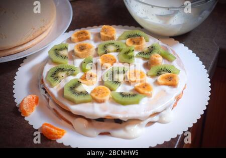 Hausgemachter Kuchen mit Honig, verzieren mit exotischem Obst: kiwi und Banane. Hausgemachter Kuchen mit Obst Stockfoto