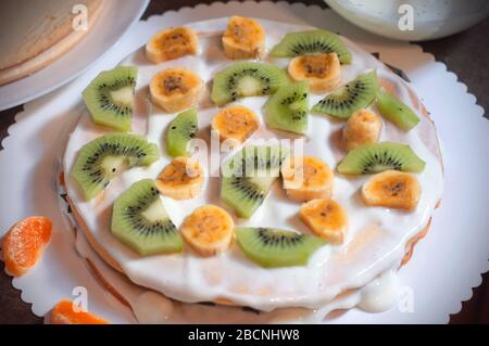 Hausgemachter Kuchen mit Honig, verzieren mit exotischem Obst: kiwi und Banane. Hausgemachter Kuchen mit Obst Stockfoto