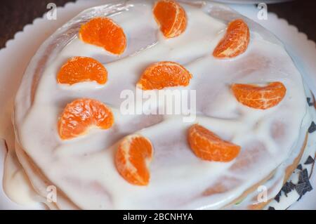 Hausgemachter Kuchen mit Honig, mit Orangenscheiben verziert. Kuchenherstellung mit Quark und Obst Stockfoto