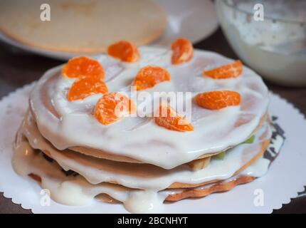 Hausgemachter Kuchen mit Honig, mit Orangenscheiben verziert. Kuchenherstellung mit Quark und Obst Stockfoto