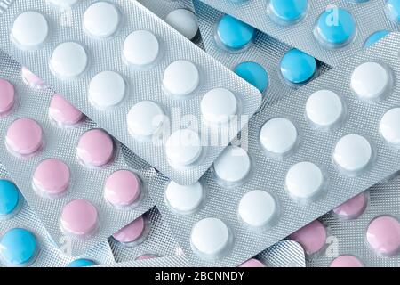 Haufen runder bunter Tabletts aus nächster Nähe, Texturhintergrund. Haufen von Blisterpillen. Pharmazie, Pharmakologiekonzept. Medikamentösen Behandlung Stockfoto