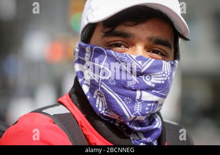 Vancouver, Kanada. April 2020. Ein Mann bedeckt sein Gesicht mit einem Schal auf der Straße in der Innenstadt von Vancouver, Kanada, 4. April 2020. Kredit: Liang Sen/Xinhua/Alamy Live News Stockfoto