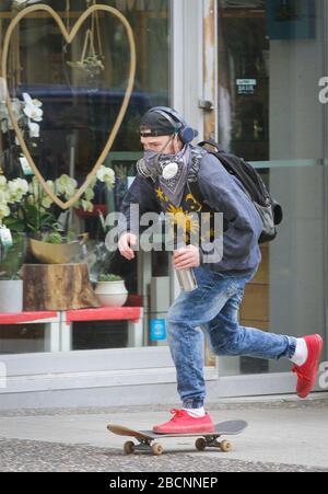 Vancouver, Kanada. April 2020. Ein Mann legt sich beim Skateboarden auf der Straße in der Innenstadt von Vancouver, Kanada, am 4. April 2020 in eine Atemschutzmaske. Kredit: Liang Sen/Xinhua/Alamy Live News Stockfoto