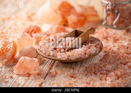 Große Kristalle aus rosafarbenem Himalayasalz in Holzschaufel Stockfoto