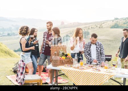 Fröhliche Freunde, die beim Picknick-Mittagessen im italienischen Weinberg essen - junge Leute haben Spaß am gastronomischen Wochenende toskana Tour - Freundschaft, Sommer und Stockfoto