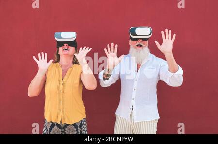 Reifere Paare haben Spaß mit der Virtual Reality Brille Technologie - Senioren surfen online, während sie VR-Headsets tragen - Tech, moderner Lifestyle und Stockfoto